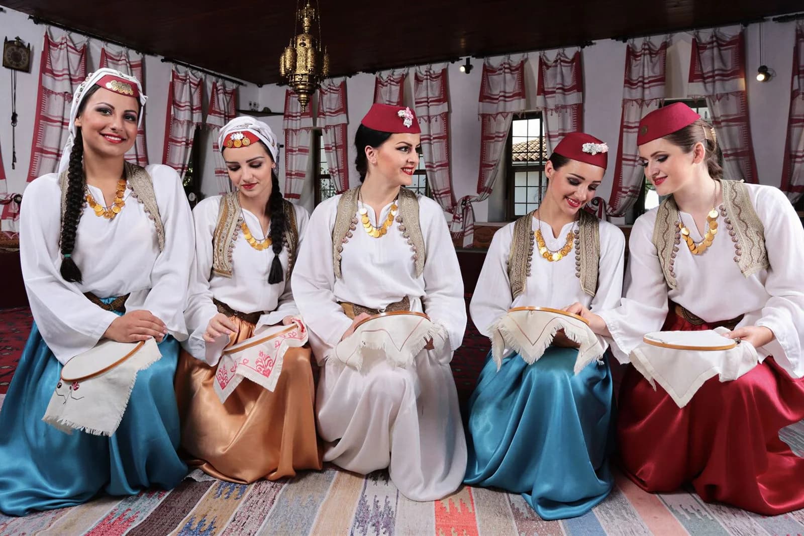 Tänzerinnen von KUD Inat in traditioneller bosnischer Tracht beim Sticken